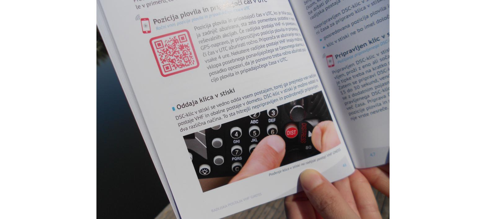 Učbenik VHF GMDSS s prikazom pritiska tipke DISTRESS za klic v stiski na radijski postaji